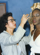 Vania Laporte concentrée et peigne à la main, coiffant durant une collection 